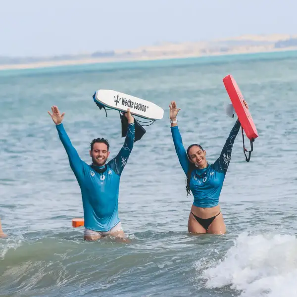 Nadador no mar erguendo um flutuador com o nome impresso